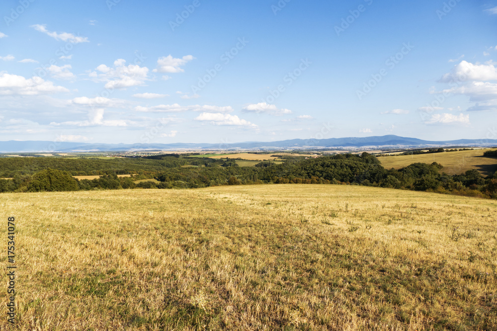 Meadow landscape in the middle of slovakia with blue sky and clouds in autumn (fall). Countryside forest with panoramic view on the hills. Autumn landscape. Beautiful hilly landscape