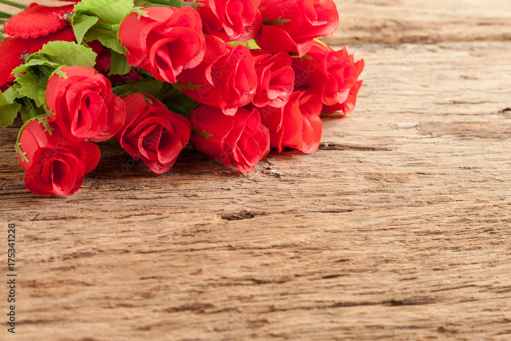 Roses and red heart on old wooden board