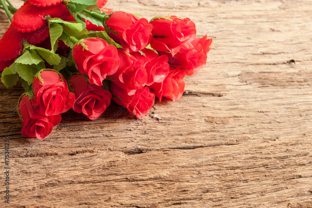 Roses and red heart on old wooden board