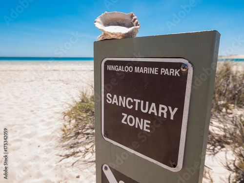 A wooden sign post at Ningaloo Marine Park in western australia. Ningaloo marine park is an ocean sanctuary zone for fish, a national park. No fishing is allowed. photo