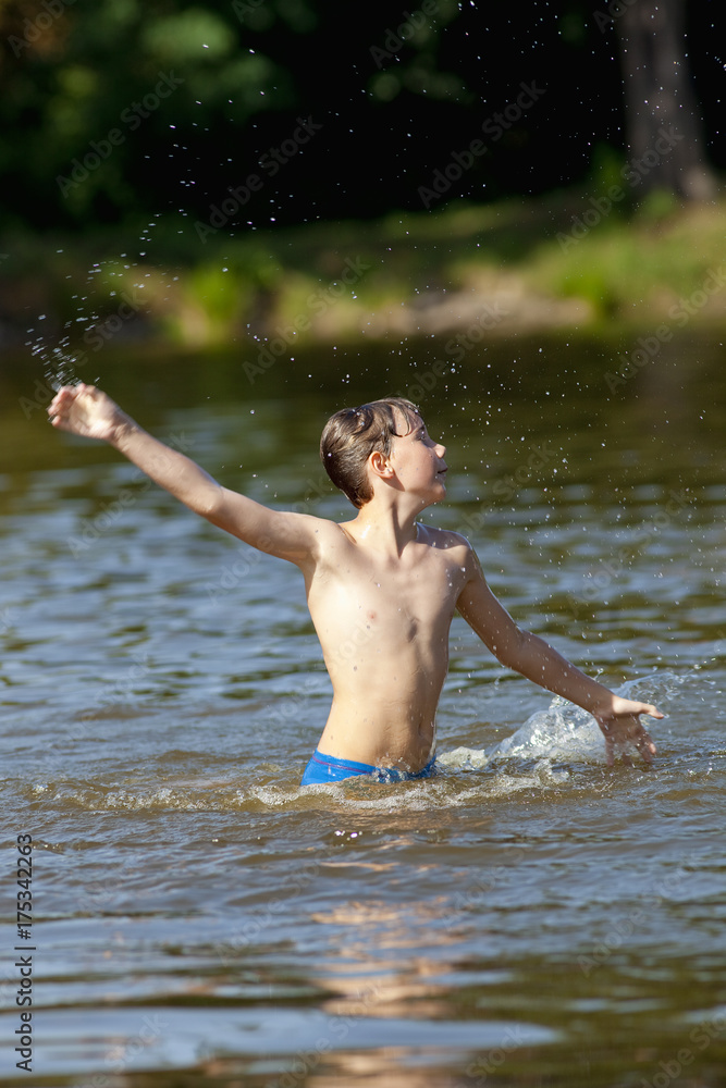 Fototapeta premium Boy Having Fun Jumping up and Splashing Water