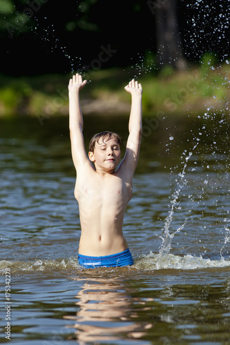 Boy Having Fun Jumping up and Splashing Water