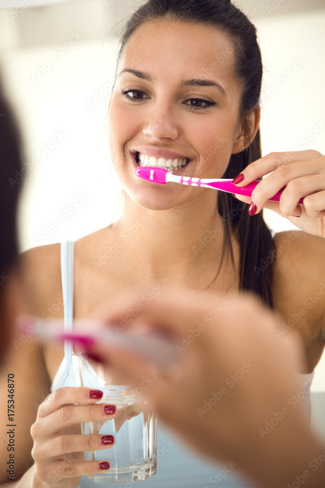 Pretty young woman brushing her teeth in the bathroom. Pretty young woman brushing her teeth in the bathroom.