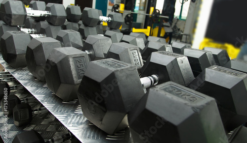 Gym. Gymnasium with sports equipment. Dumbbells, barbells, dumbbells - equipment to work on muscle mass. Morning exercises for vitality afternoon. Rows of dumbbells in the gym.