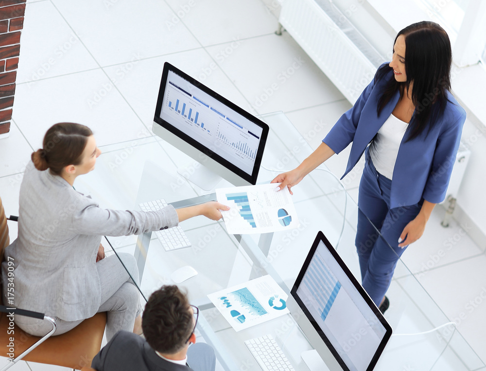 A satisfied business lady explains the statistics chart to her c A satisfied business lady explains the statistics chart to her c