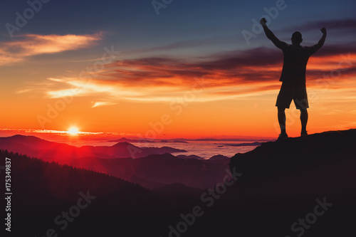 Man silhouette on mountain cliff enjoy panaoramic view. Man watch over misty and foggy morning valley in morning Sun.