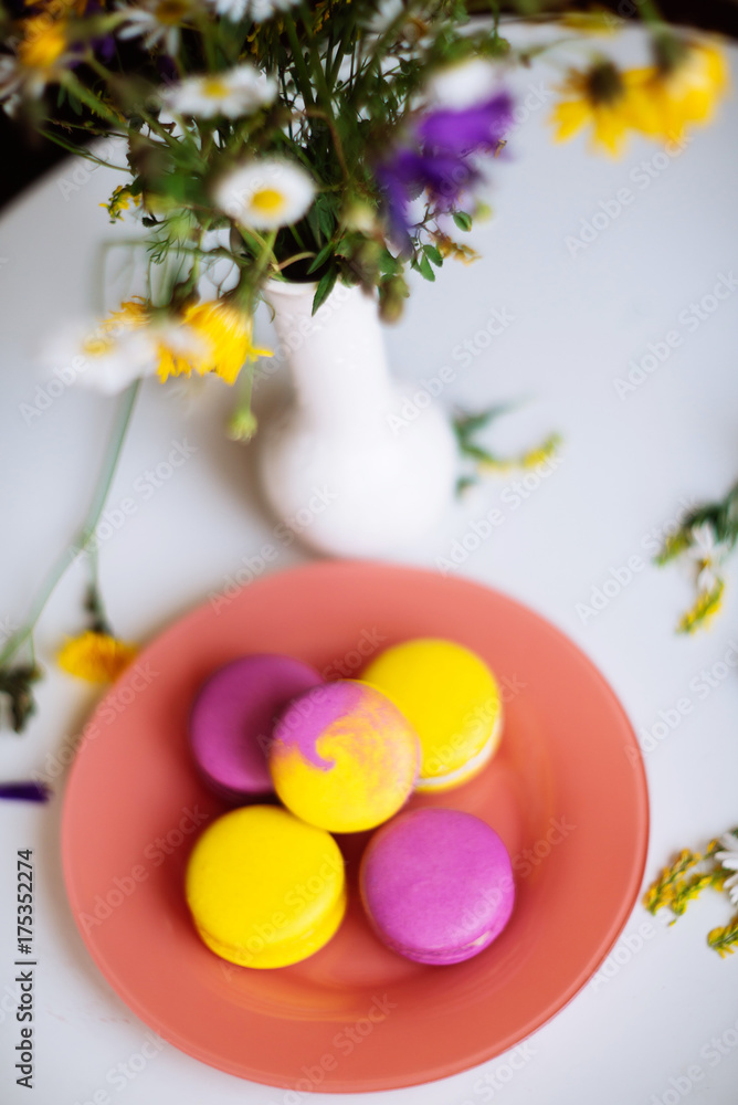 Macaroons and pink flowers tulips on white rustic wooden table with place for text. Present on Mothers day, Valentines Day or Womens day. Gritings woman concept. Copy space. Macaroons and pink flowers tulips on white rustic wooden table with place for text. Present on Mothers day, Valentines Day or Womens day. Gritings woman concept. Copy space.