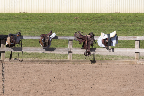 three saddles on a fence