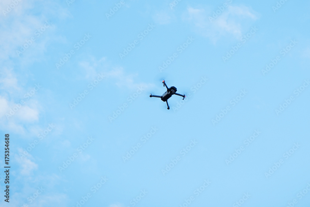 Modern drone hovering in blue sky Modern drone hovering in blue sky