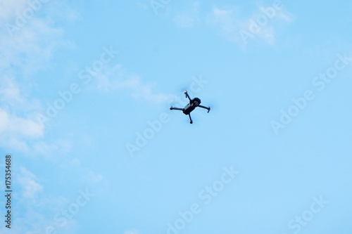 Modern drone hovering in blue sky