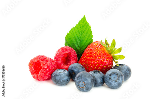 Close-up arrangement with mixed, assorted berries including blackberries, strawberry, blueberry and raspberries and fresh leaf isolated on white. Colorful, healthy concept. Black, blue, red, green