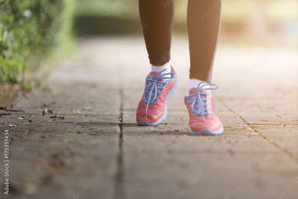 young woman runner feet running closeup on shoe,women jogging with dirty shoes in a park