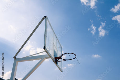 Basketball basket with transparent backboard on beautiful sky 