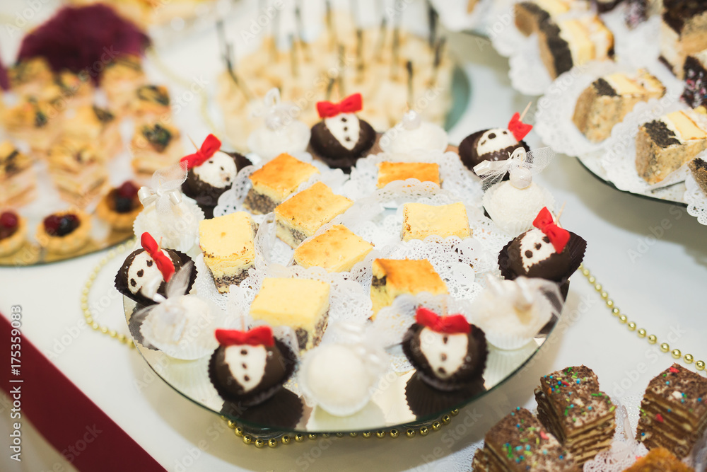 Obraz premium Delicious and tasty dessert table with cupcakes shots at reception closeup