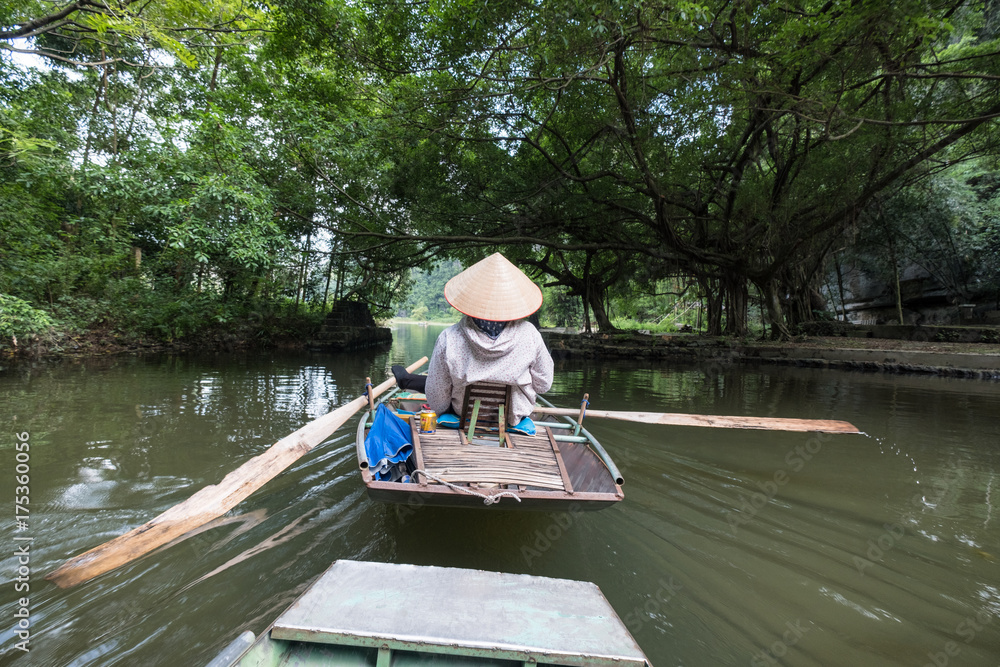 Fototapeta premium Activity downstream on boat with vietnamese using foot paddle in Ngo Dong river