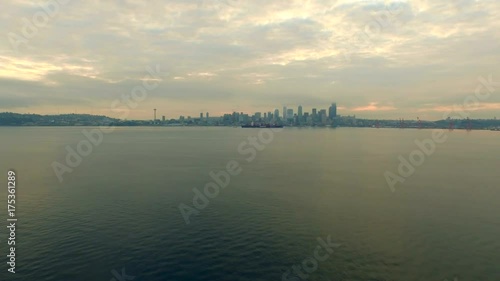 Seattle, WA downtown waterfront view at sunrise, early mourning, warm colors, calm water and some light fog, establishing shot
