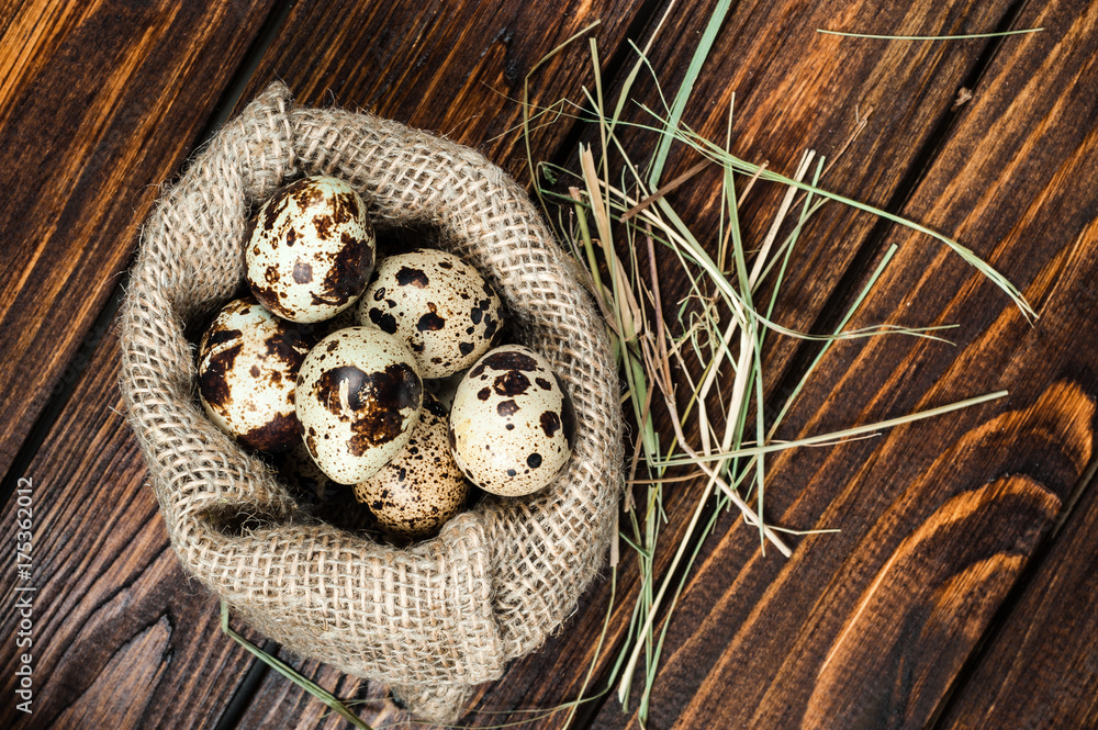 top view on quail eggs in burlap sack over old wooden background top view on quail eggs in burlap sack over old wooden background