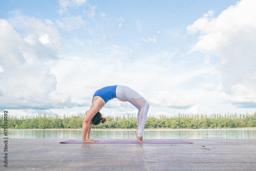 asian woman practice Yoga beside the river