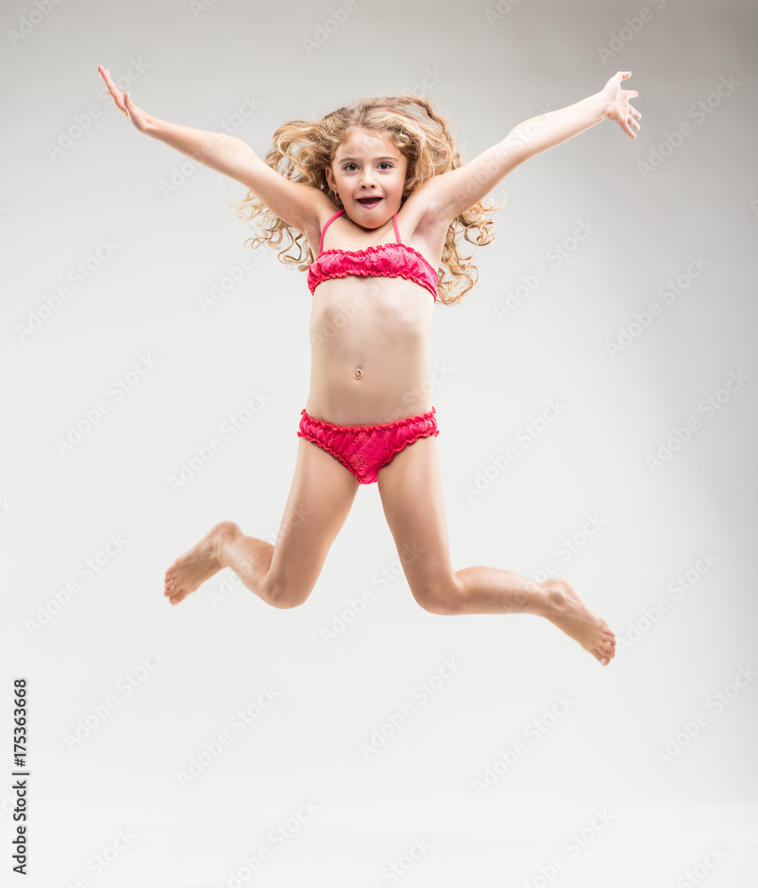 Agile exuberant little girl leaping in the air