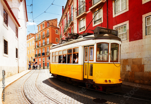 yellow tram on narrow street of Alfama district, Lisbon, Portugal, retro toned © neirfy
