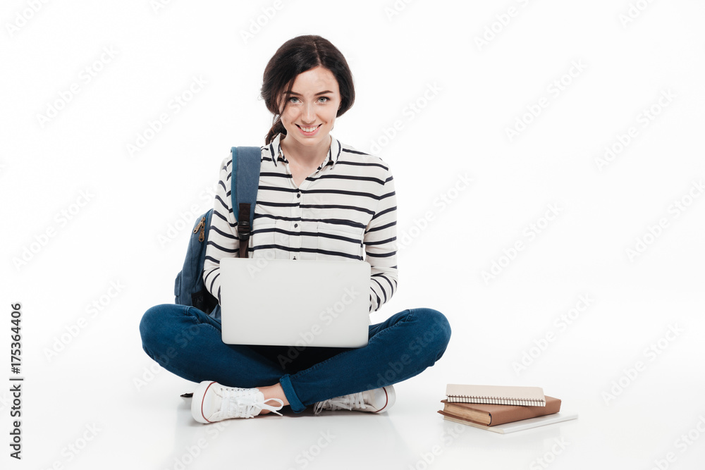 Portrait of a happy teenage girl with backpack using laptop Portrait of a happy teenage girl with backpack using laptop