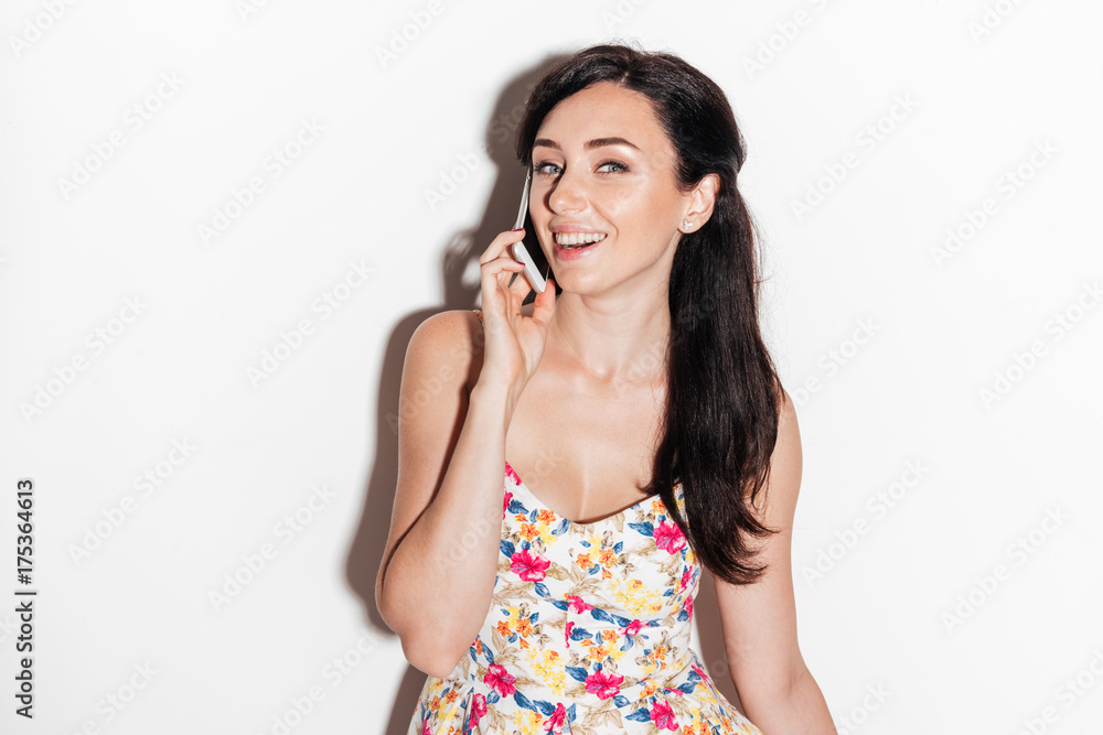 Happy brunete woman talking by smartphone and looking at camera Happy brunete woman talking by smartphone and looking at camera