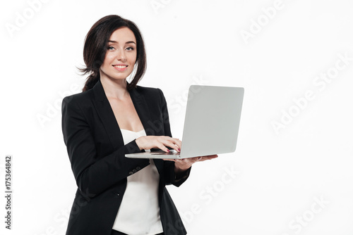 Portrait of a happy smiling businesswoman in a suit typing