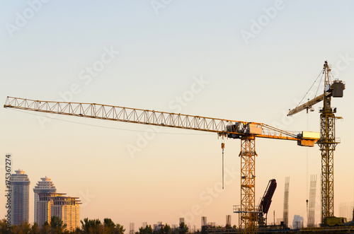 Industrial cranes building in the city with the clear sky and sunset