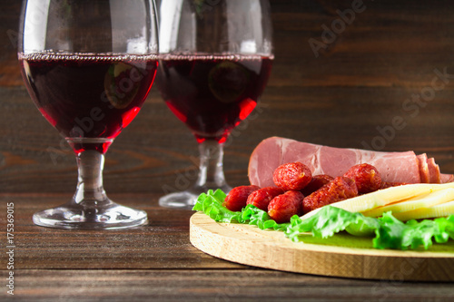 Red wine with charcuterie assortment on the background