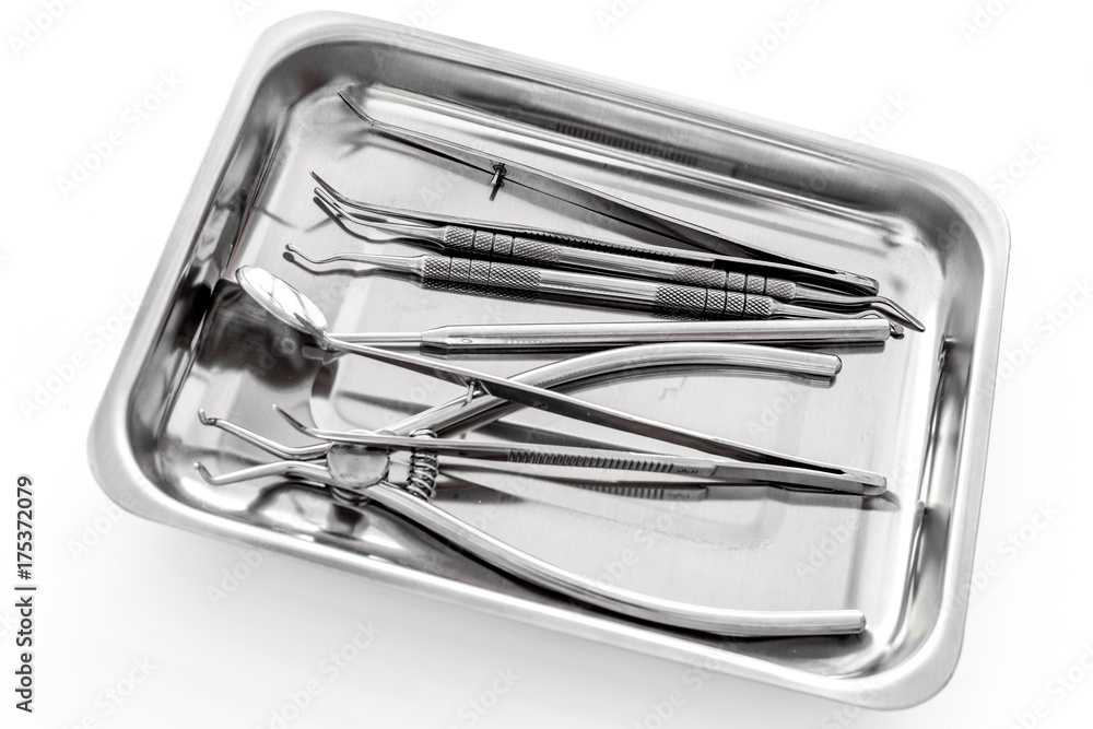 Basic dentists tools in cuvette on white background Basic dentists tools in cuvette on white background