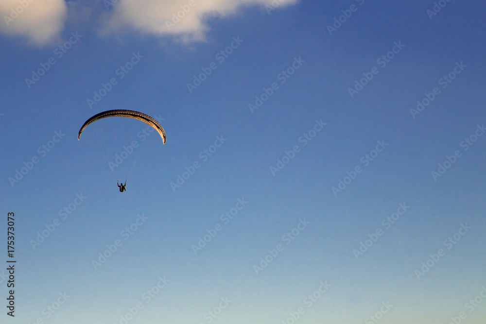 Paraglider flies in the blue sky. Paraglider flies in the blue sky.