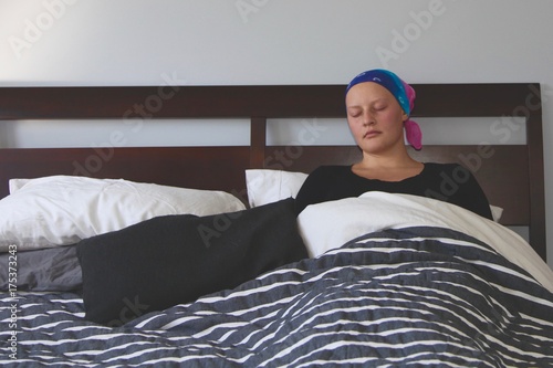 Young cancer patient in a headscarf sleeping in bed