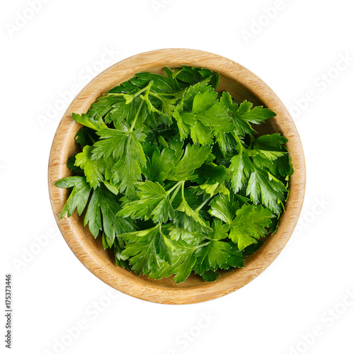 Fresh parsley leaves in a wooden bowl isolated on white. Top view.