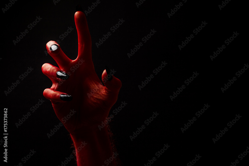 Fototapeta premium Red devil creepy halloween hand on a black background