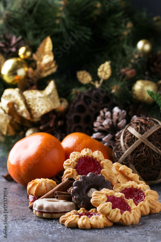 A set of Christmas decorations with tangerines, cookies over a stone background. Top view