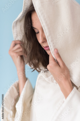 woman in a white coat with hood isolated on blue background