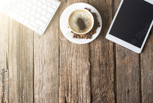 digital tablet and coffee cup on wooden table