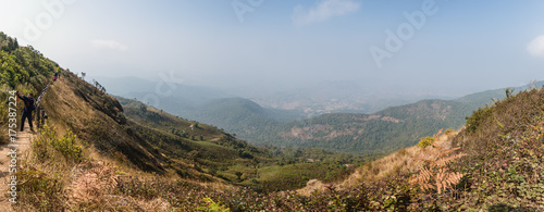 Mountain Panoramic view with golden grass and many mountains with fog in the background at Kew Mae Pan Mountain Ridge in Chiang Mai, Thailand.