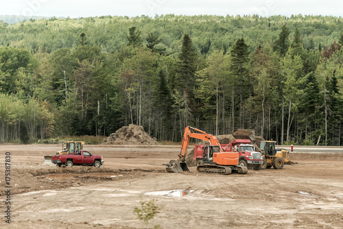 Clearcut forest deforest machines trucks excavator in New Brunswick Canada