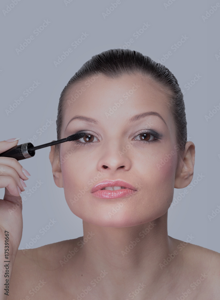 Beautiful woman is using mascara