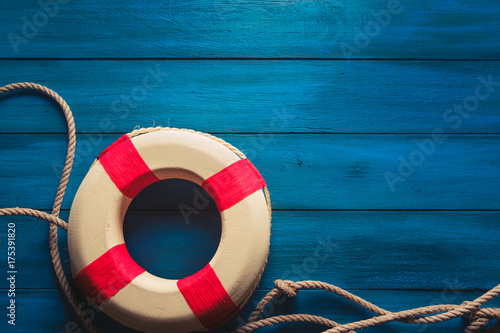 life saver with rope on a blue wooden background