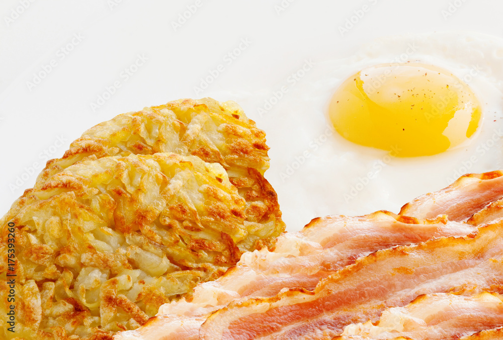 Bacon, fried peppered egg and hash browns on a white background