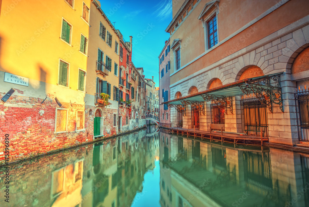 Historical streets in water canal filled with green water, Venice, Italy