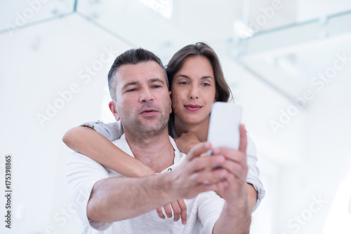 happy couple using mobile phone at home