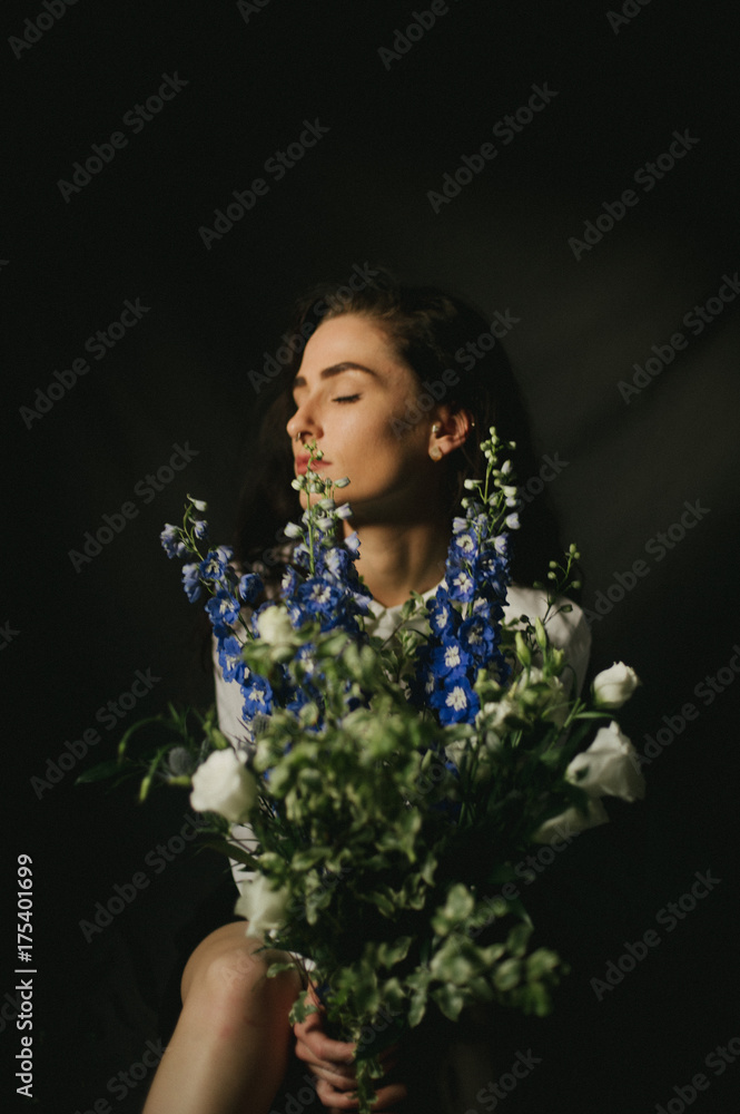 Model with white button up shirt, purple flower bouquet in basement lit by natural window light Model with white button up shirt, purple flower bouquet in basement lit by natural window light