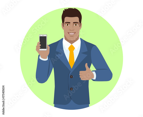 Businessman holding mobile phone and shows thumb up