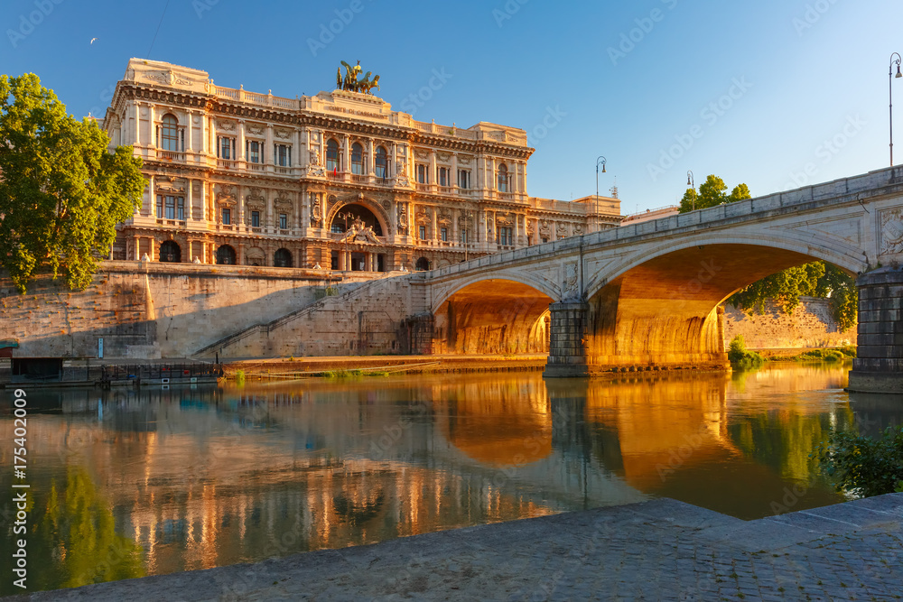 The Palace of Justice and bridge Ponte Umberto I with mirror reflection seen from the Tiber riverside at sunrise in Rome, Italy