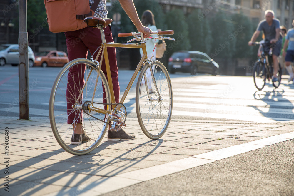 Man standing next to the bicycle waiting to cross the street Man standing next to the bicycle waiting to cross the street
