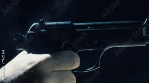  Plano detalle de pistola disparando. Cámara lenta.