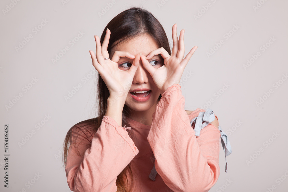 Asian woman do funny double OK sign as glasses. Asian woman do funny double OK sign as glasses.